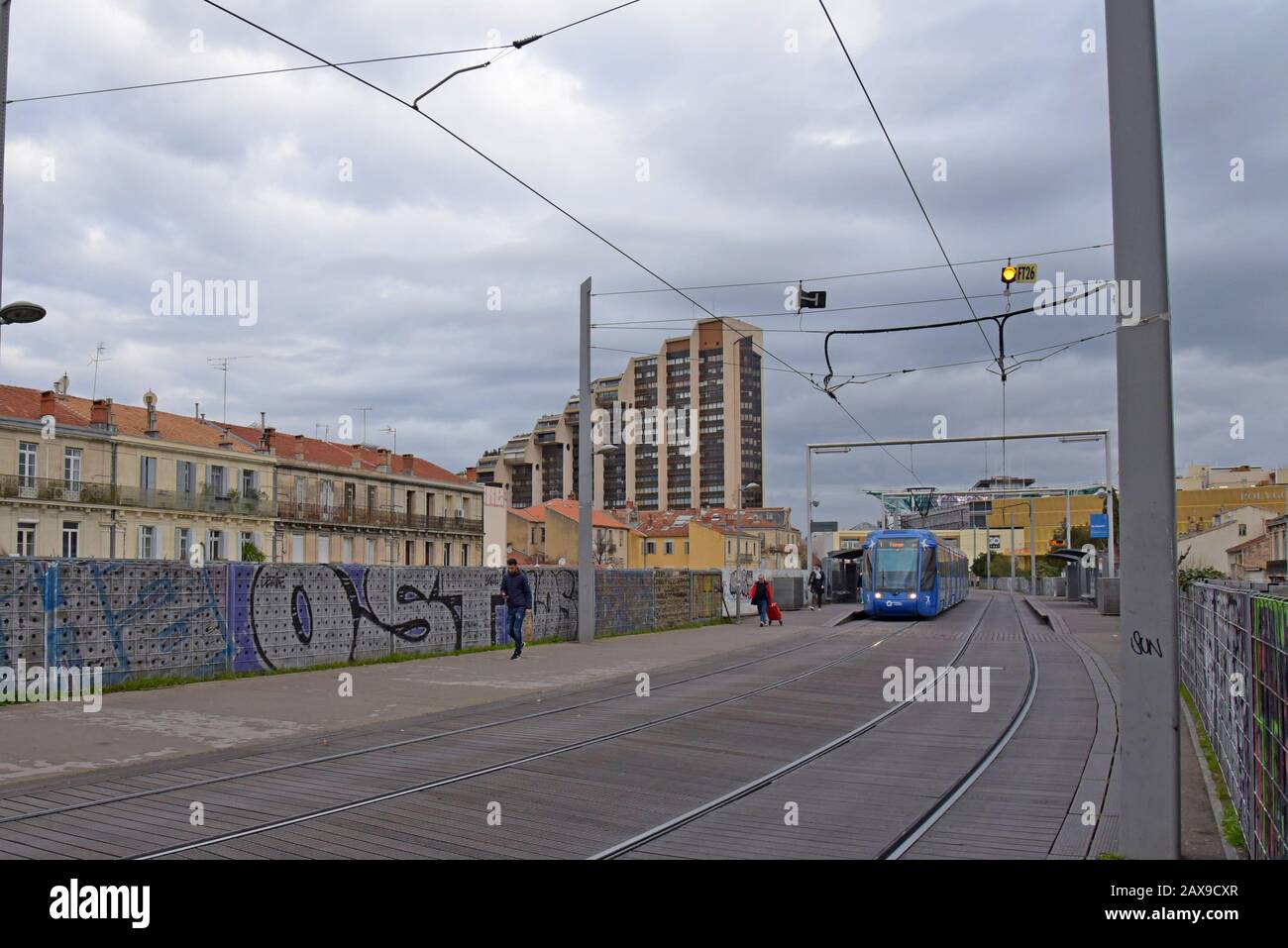 A Montpellier tram on the elevated section of the network alongside traditional housing near the city centre, Montpellier, France Stock Photo