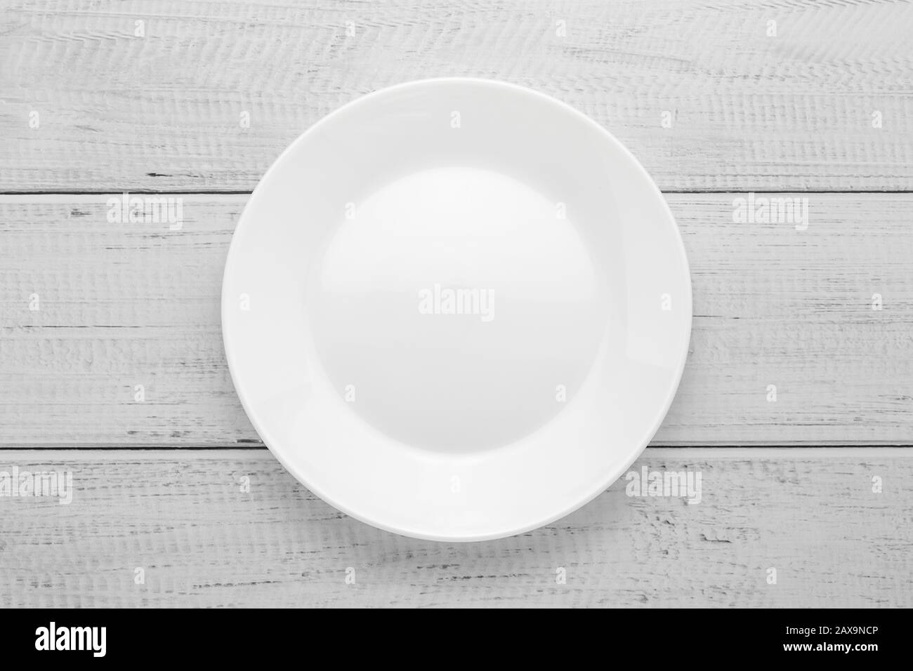 Empty white plate on gray wooden table. Top view. Wood board background Stock Photo