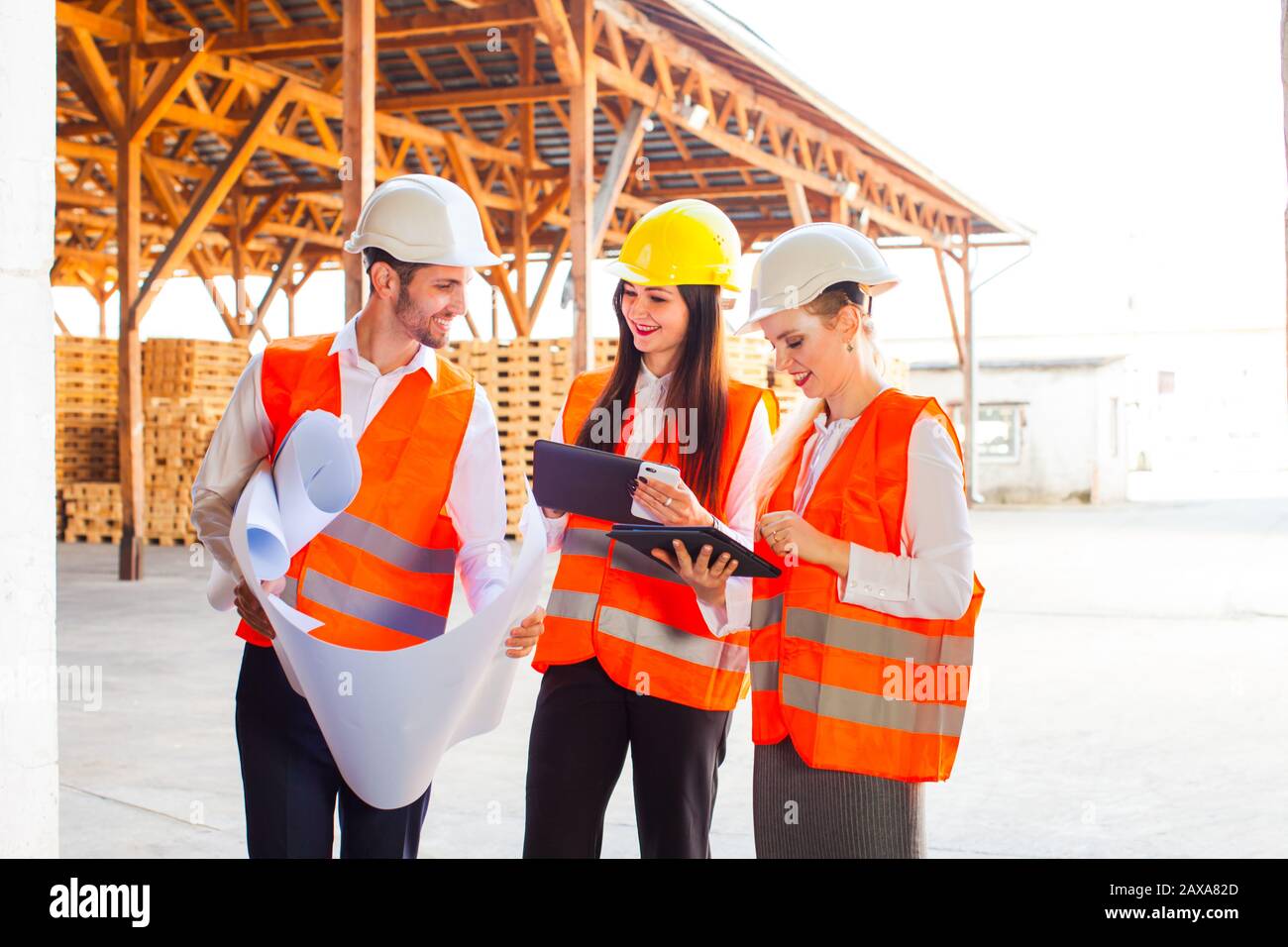 Team of young architects using tablet and blueprints Stock Photo