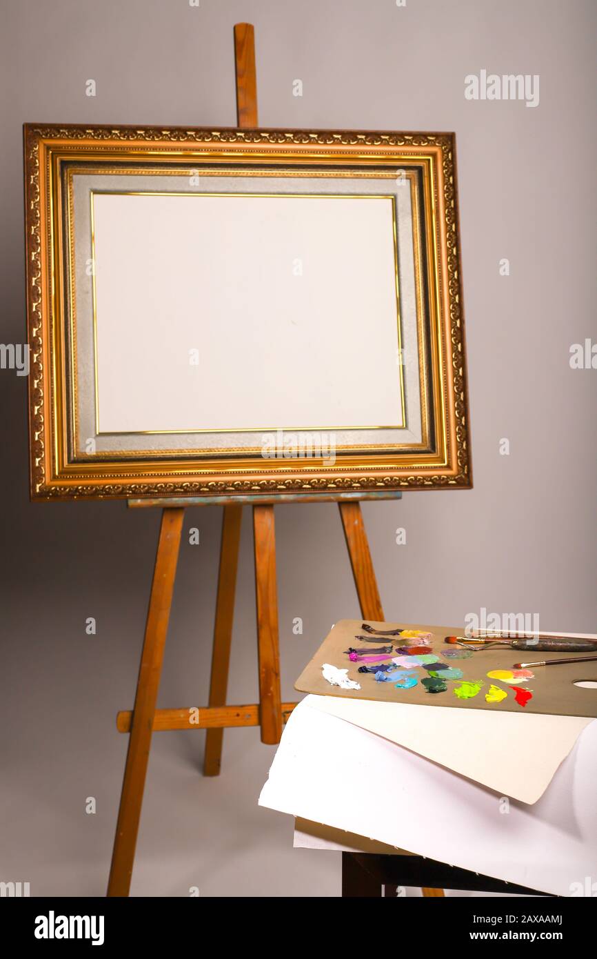 Wooden easel with a empty canvas, palette and brush, Stock image