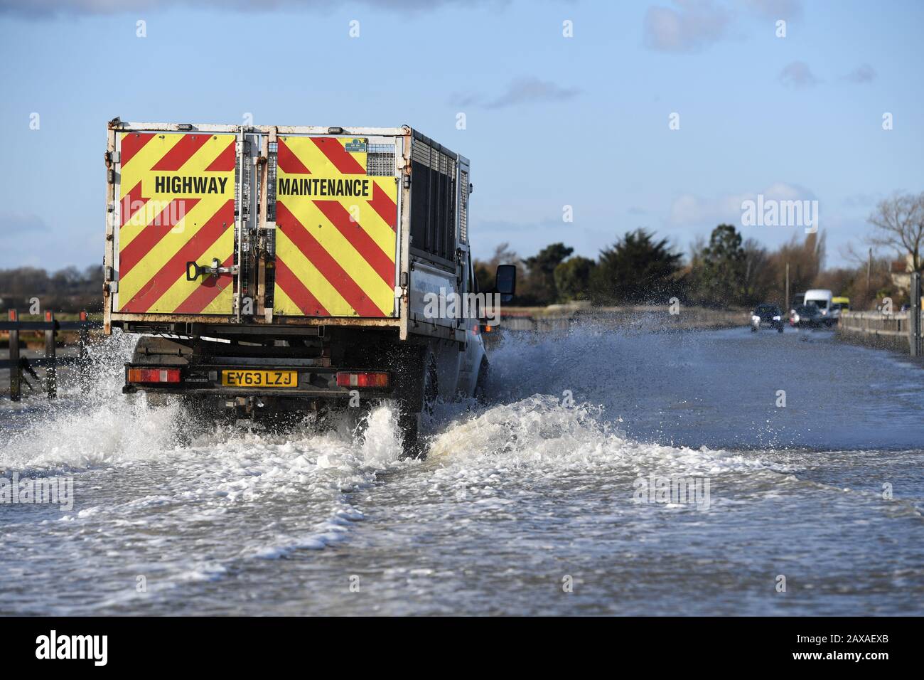 A vehicle travels on The Strood causeway, which joins the mainland to Mersea Island in Essex, to clear as, elsewhere in the UK, rain and wind caused by storm Ciara gave way to hazardous amounts of snow and ice. Stock Photo