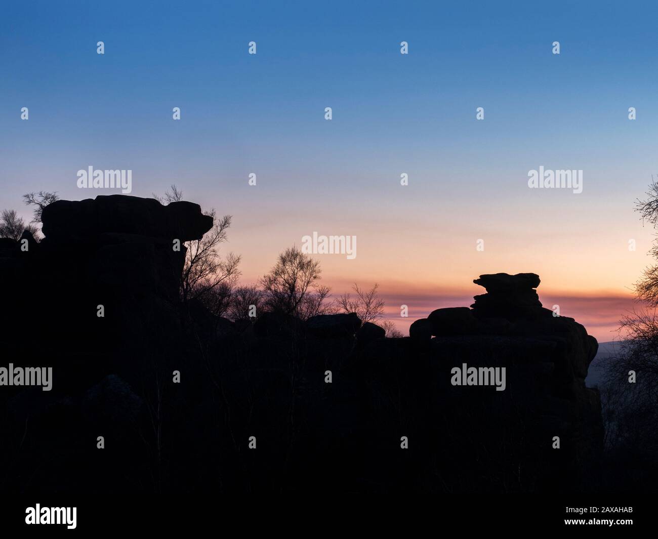 Rocks formations silhouetted against a winter twilight sky at Brimham Rocks Brimham Moor Nidderdale AONB North Yorkshire England Stock Photo
