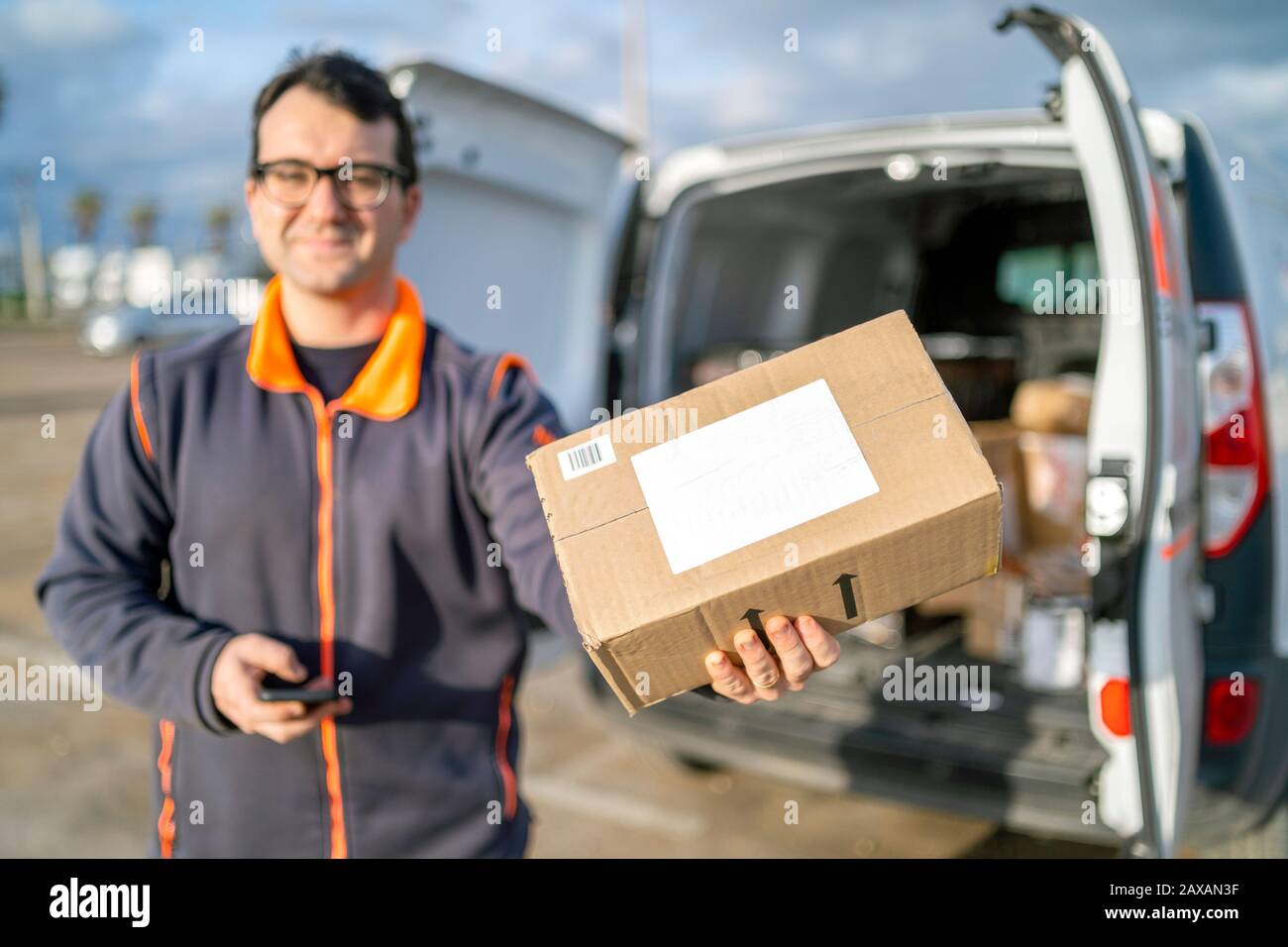 Delivery man carrying parcel hires stock photography and images Alamy