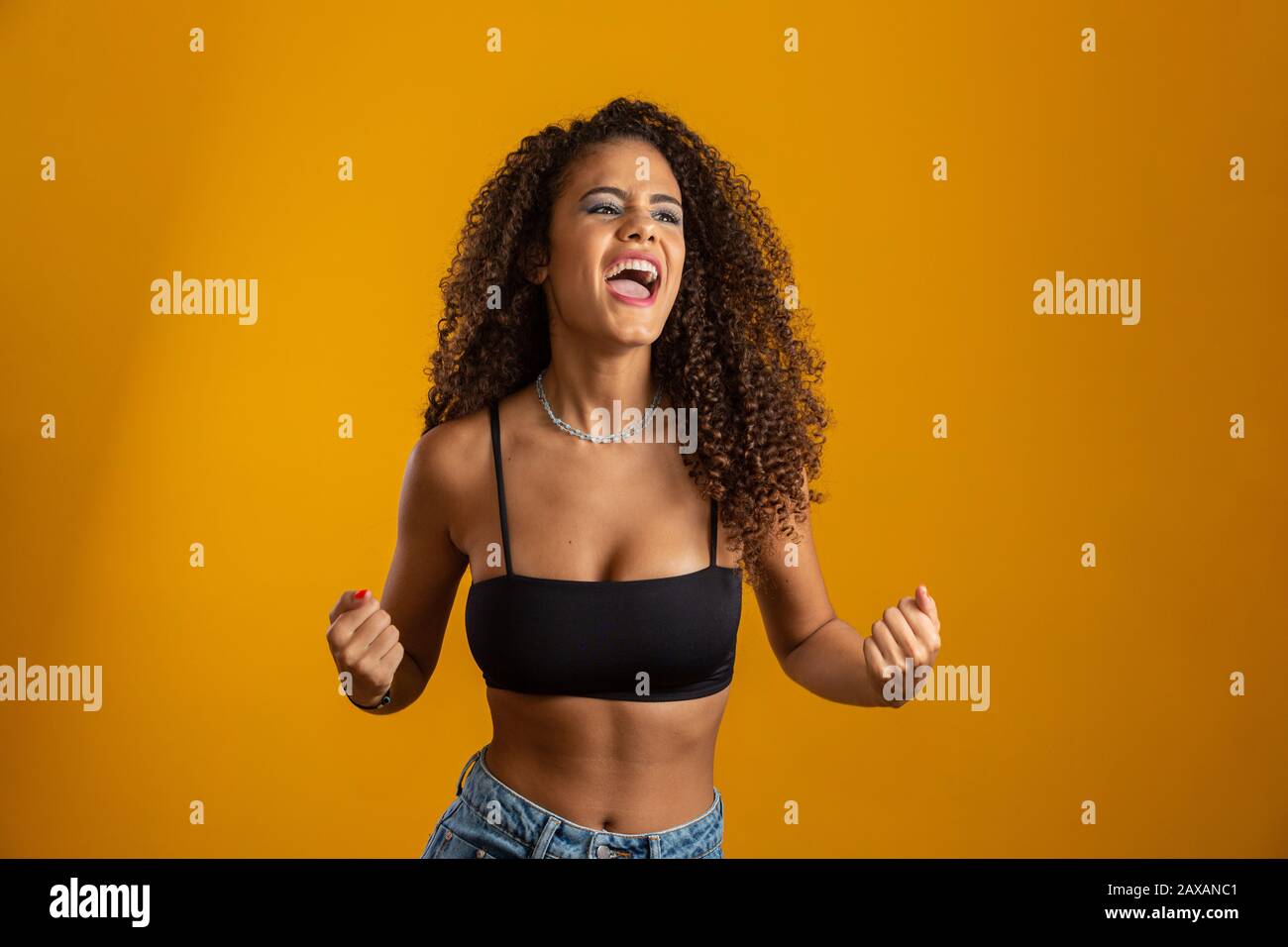 Overwhelmed excited smiling, happy afro curly hair girl celebrating amazing news, achieve victory, winning competition, gain goal or unexpected lucky Stock Photo
