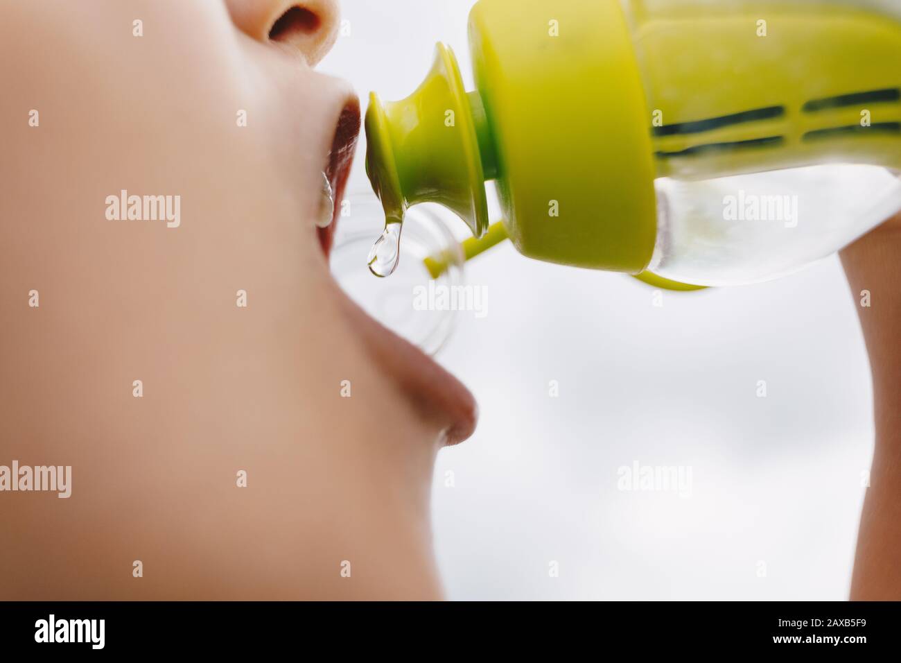 Little sports boy drinking water from filtering water bottle. Water