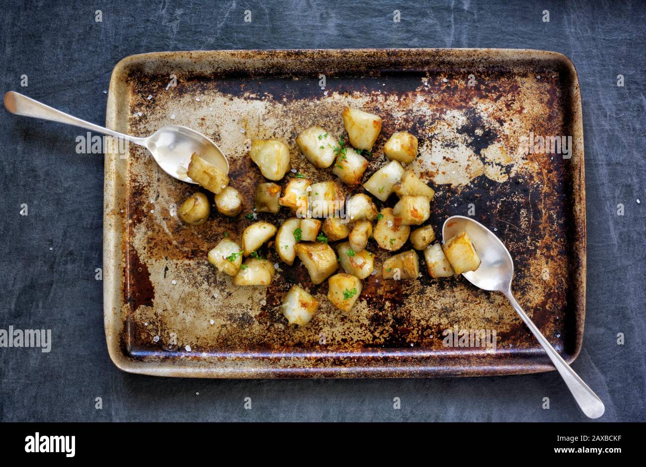 Roasted Jerusalem Artichokes on a roasting tray. Stock Photo