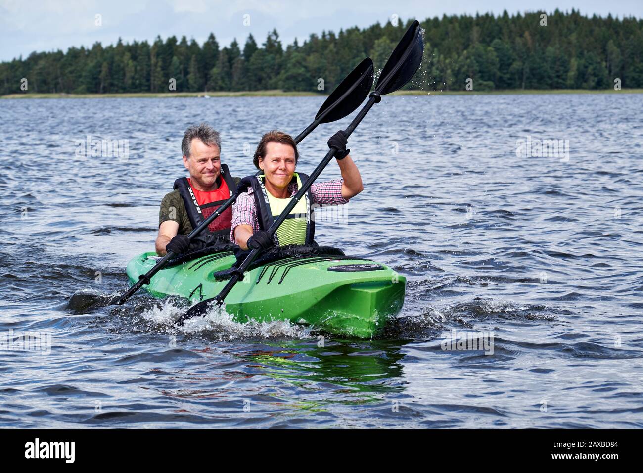 male and female couple kayaking in unison on Lake Åsnen, Sweden Stock Photo
