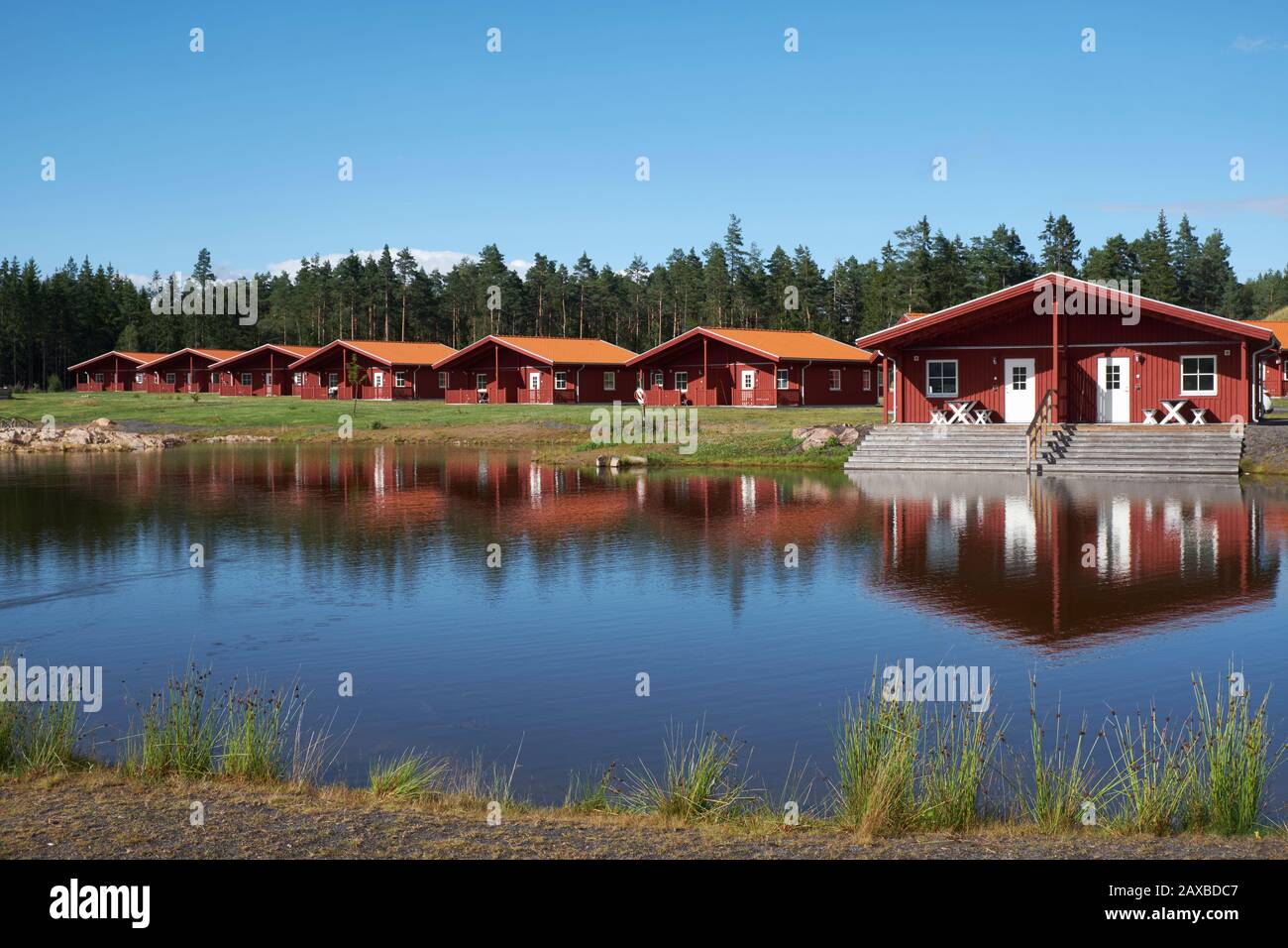 Lakeside red painted wooden holiday chalets at Kosta Lodge Stock Photo