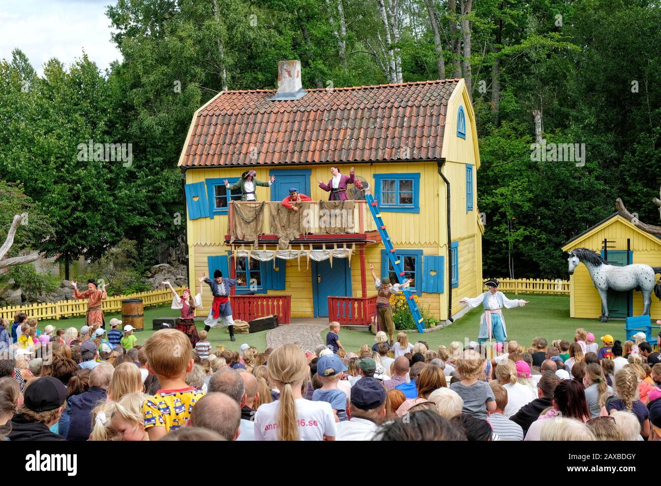 Live show of Pippy Longstocking at Astrid Lindgren's World showing the actors performing to a mixed audience with Villa Villekulla as decor Stock Photo
