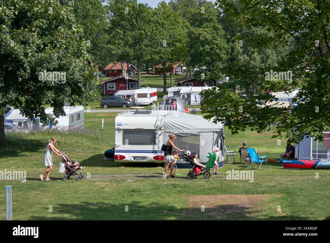 Campsite scene with caravans and wooden holiday chalets Stock Photo