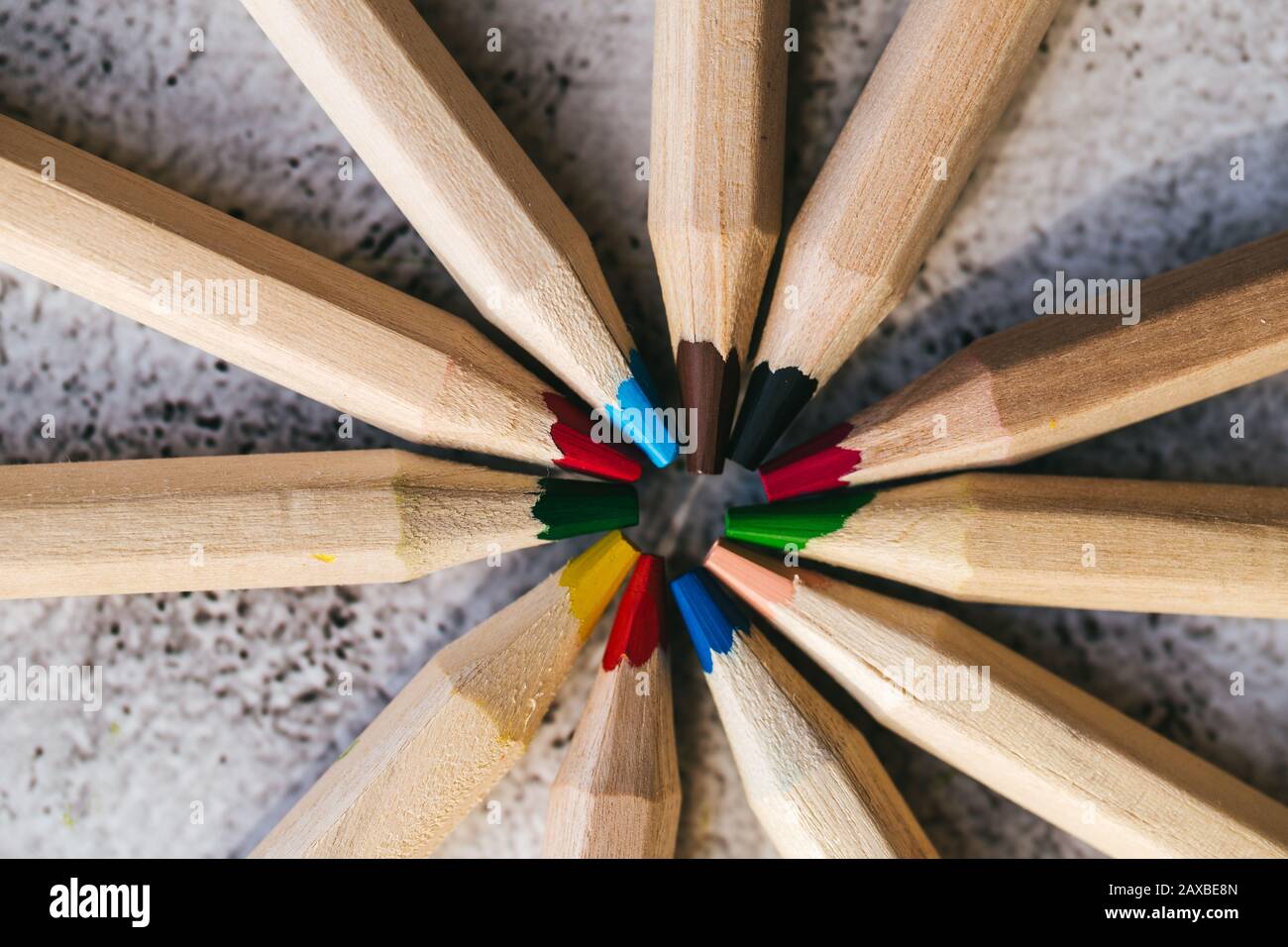 Many different colored pencils in a circle on gray background Stock Photo
