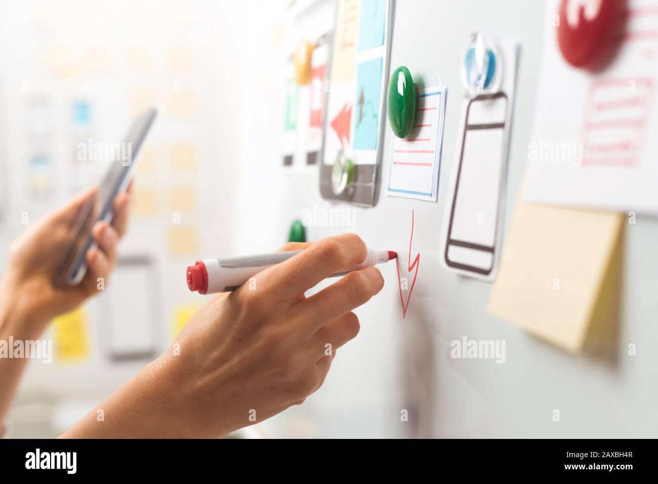 UI website designers are developing a mobile phone application interface. User experience Stock Photo