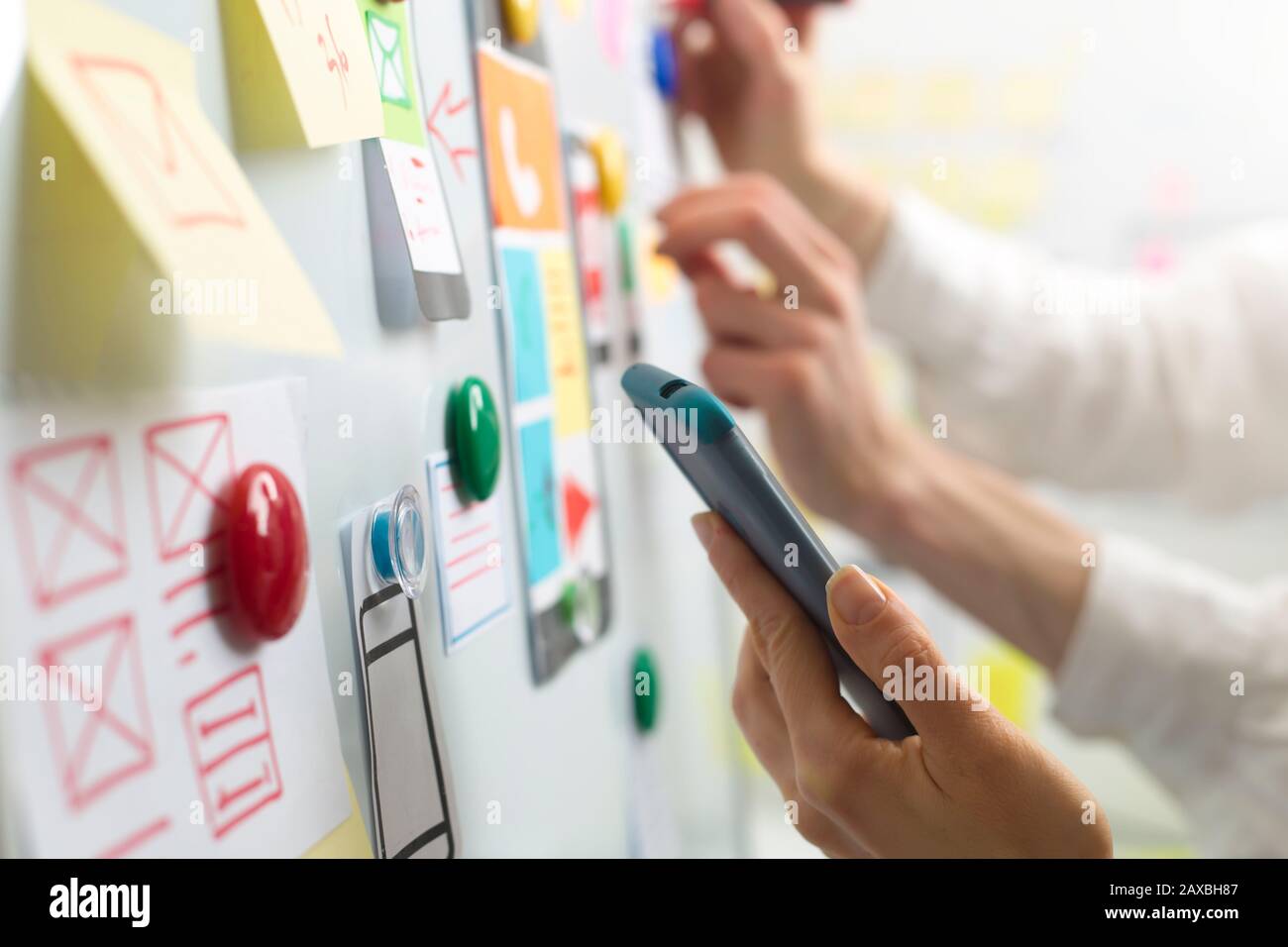 UI website designers are developing a mobile phone application interface. User experience Stock Photo