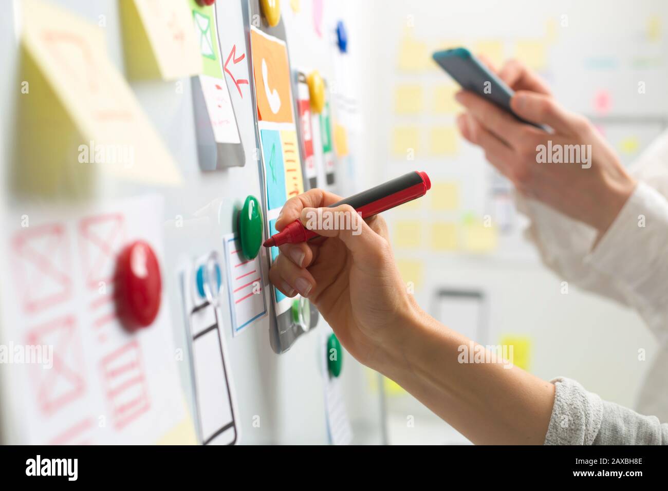 UI website designers are developing a mobile phone application interface. User experience Stock Photo