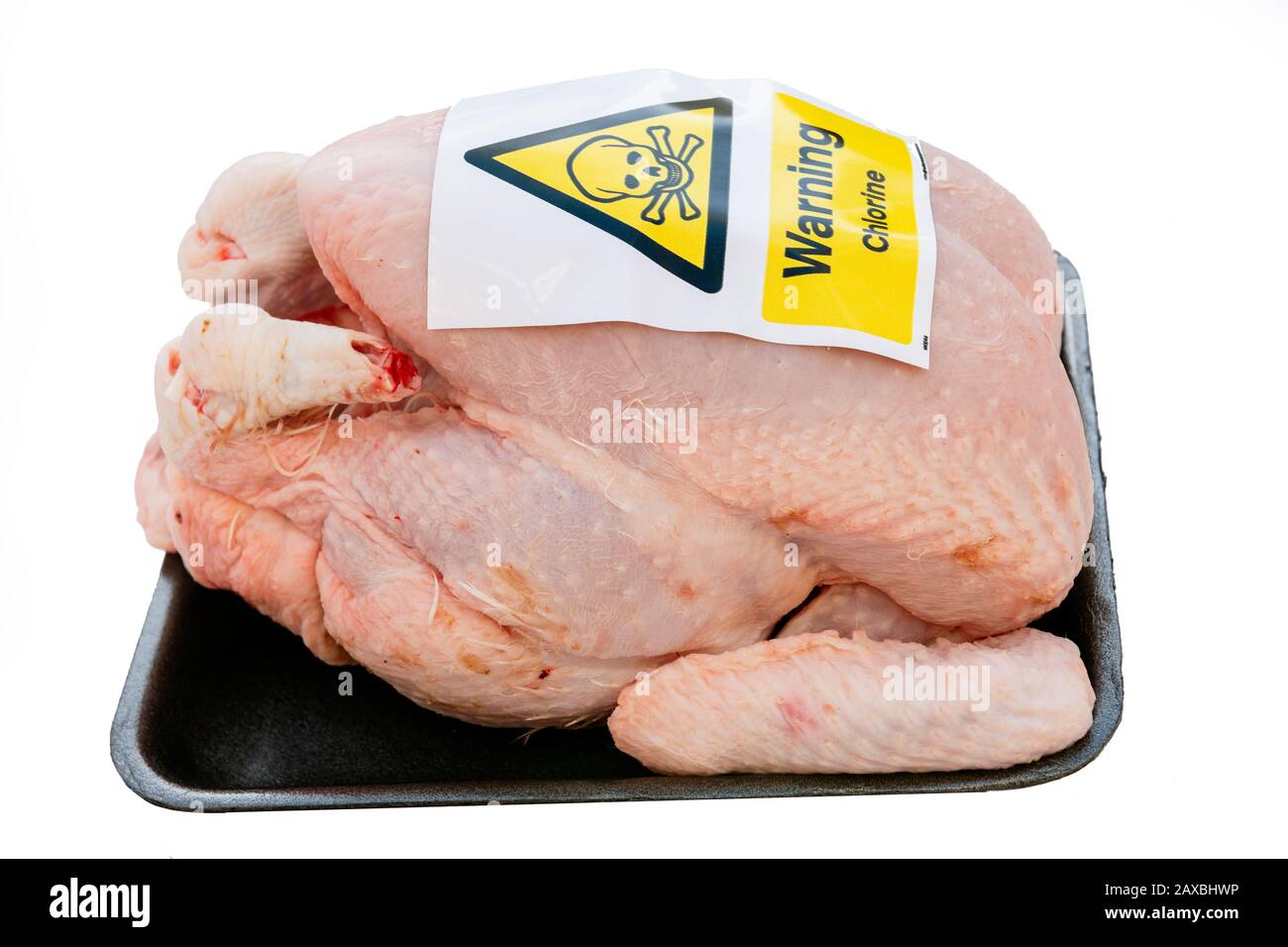 Chlorinated chicken concept, cut out or isolated on a white background. Chlorine warning sticker on a raw chicken, UK. Stock Photo