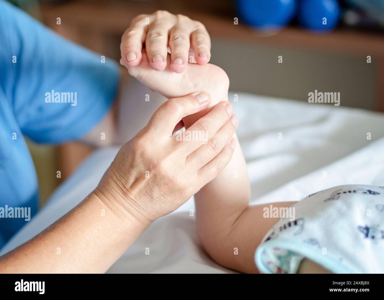 Baby having foot massage in a rehabilitation centre. Little child on