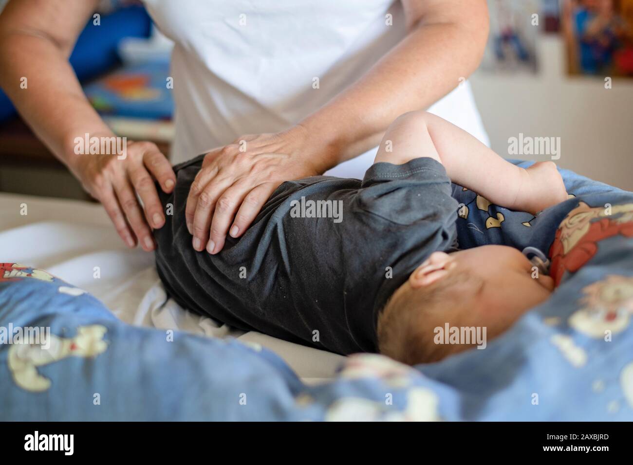 Baby having massage in a rehabilitation centre. Little child on therapy. Massage therapist massaging a baby patient. Stock Photo