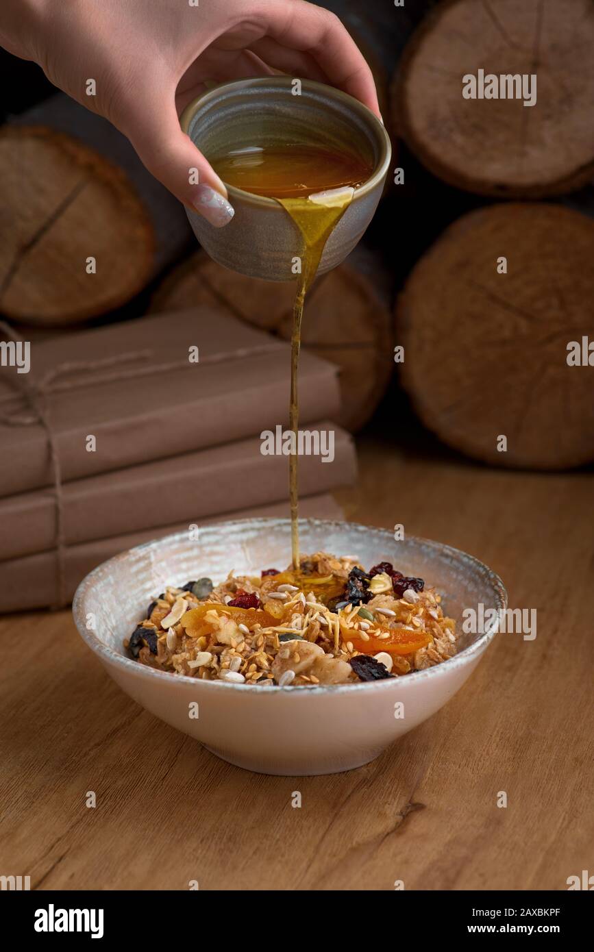 Healthy breakfast concept. Oatmeal, quinoa granola with yogurt, dried fruit, seeds, honey in bowl, copy space. Allergy-friendly, gluten free concept. Stock Photo