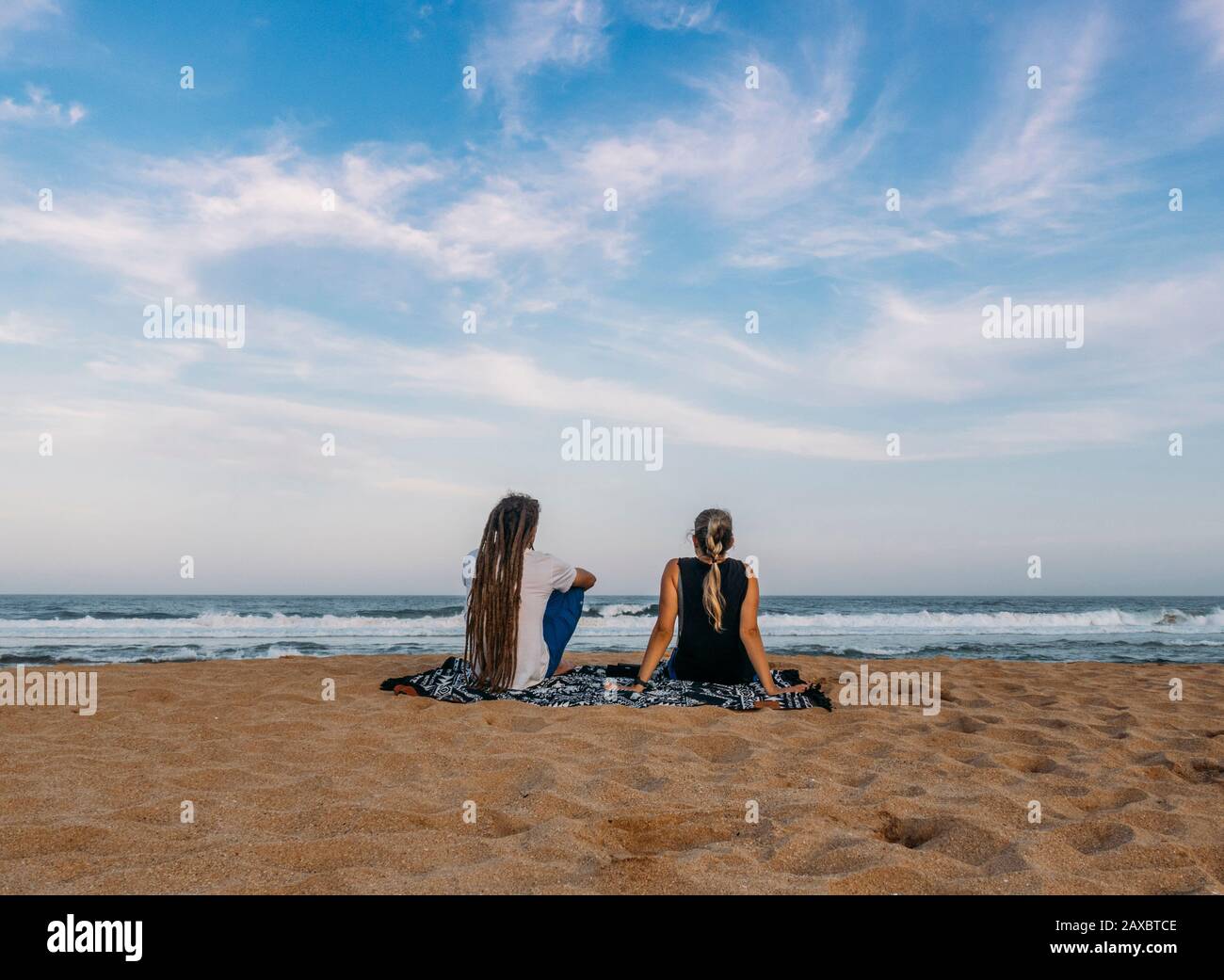 Couple relaxing on tranquil ocean beach Kiama Australia Stock Photo