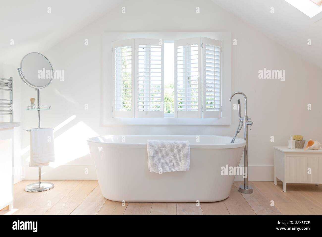 Tranquil white home showcase bathroom with soaking tub Stock Photo
