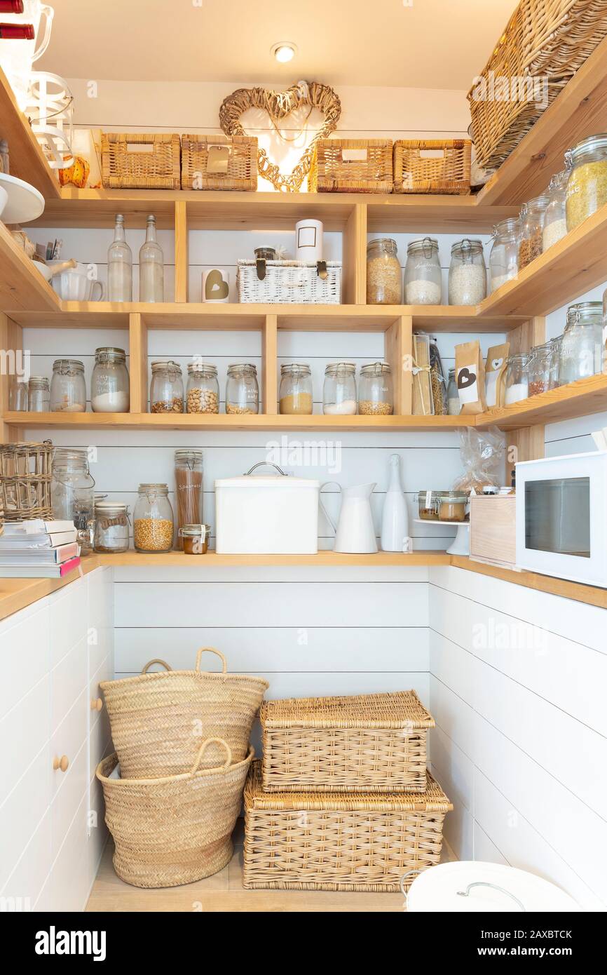 Woven baskets and food jars in pantry Stock Photo