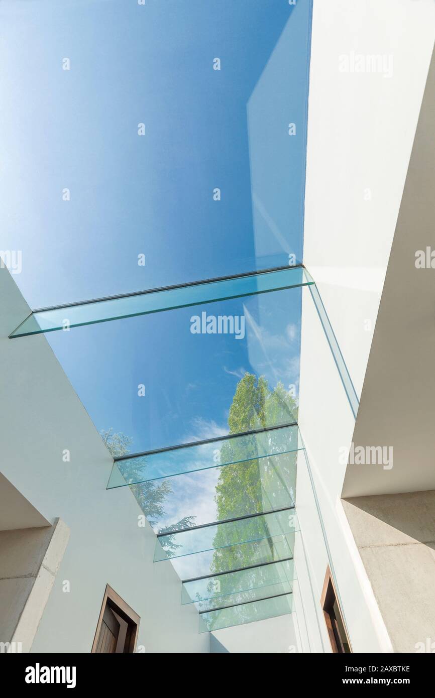 Modern glass skylight below sunny blue sky Stock Photo