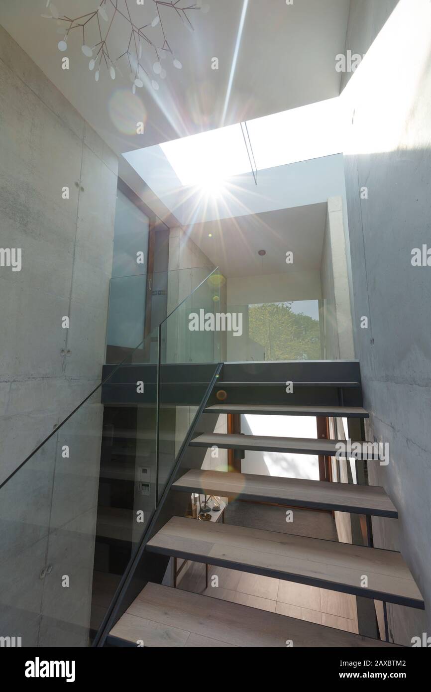 Sunlight shining through skylight over modern staircase in house Stock Photo