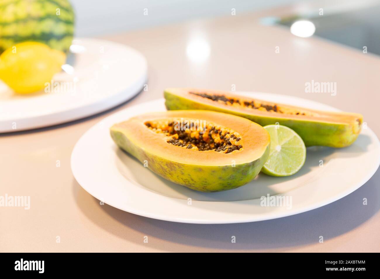 Fresh cut papaya with lime on plate Stock Photo