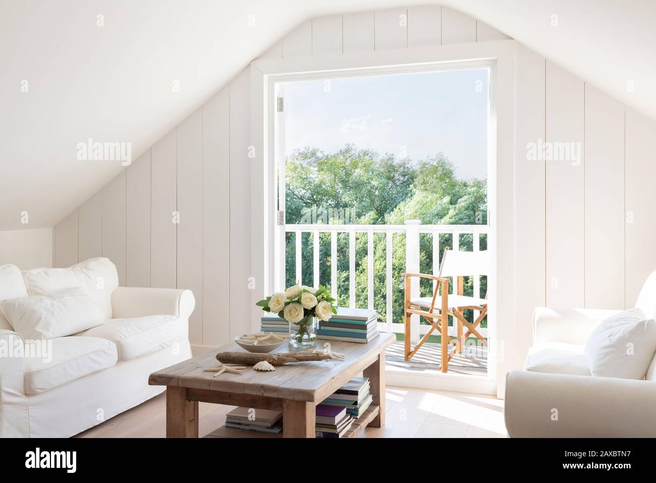 A-frame attic sitting area open to sunny summer patio Stock Photo