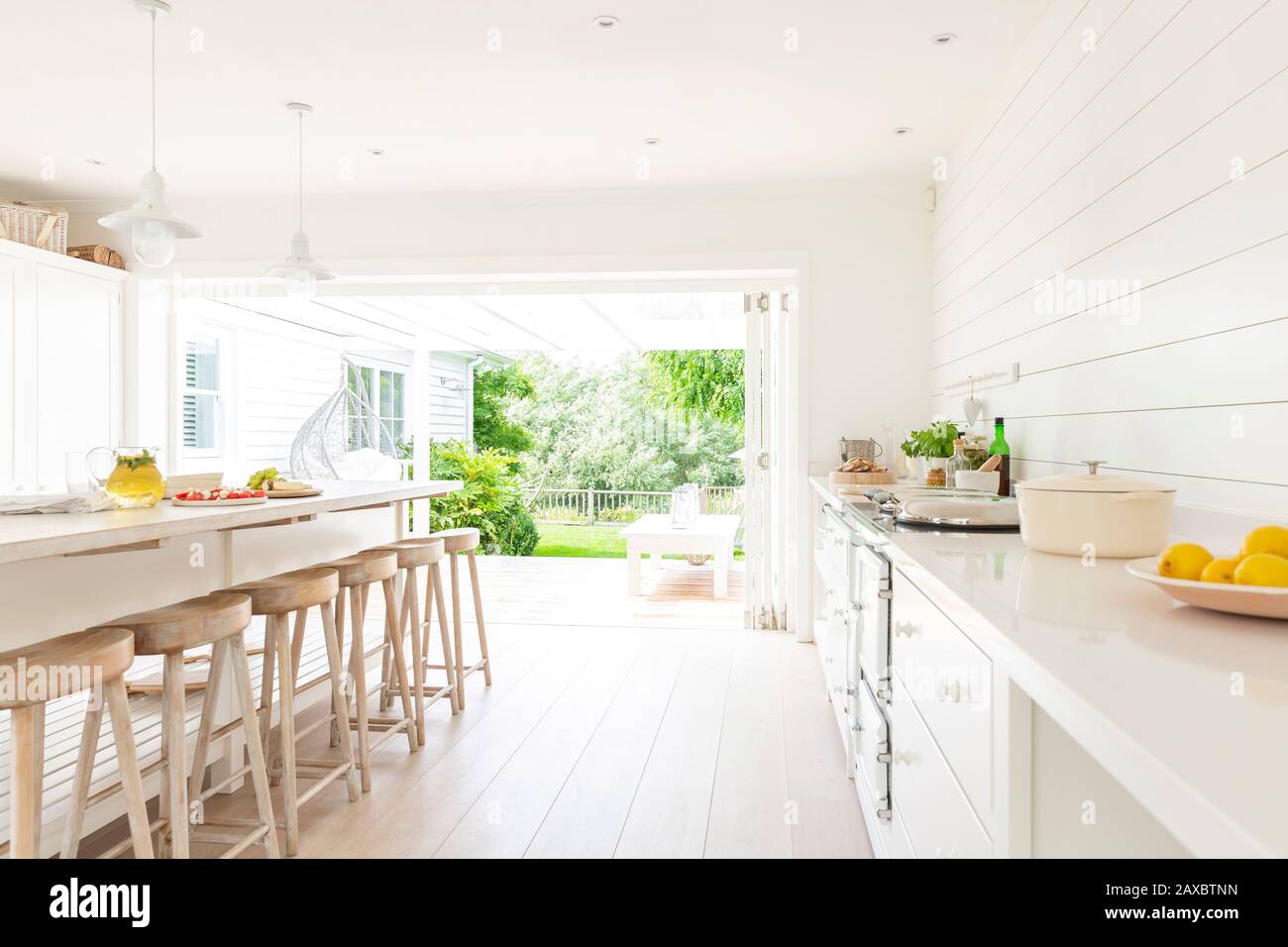 Simple white home showcase interior kitchen open to patio Stock Photo