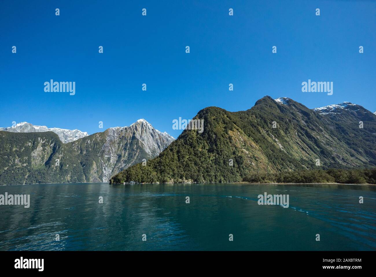 The Milford Sound Discovery Centre and Underwater Observatory dwarfed by the steep walls of the sound. Stock Photo