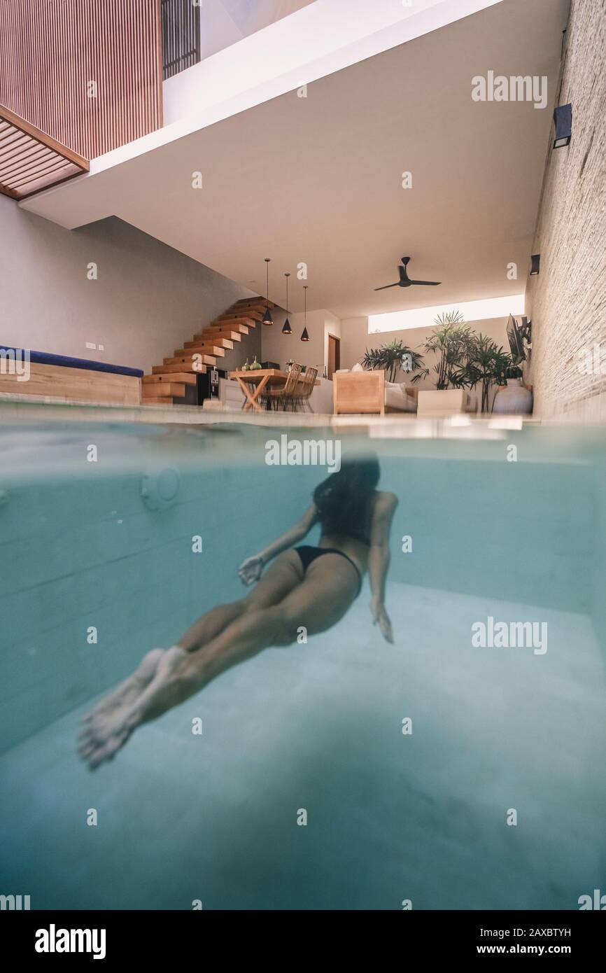A vertical shot of a woman swimming in an in-house pool Stock Photo - Alamy