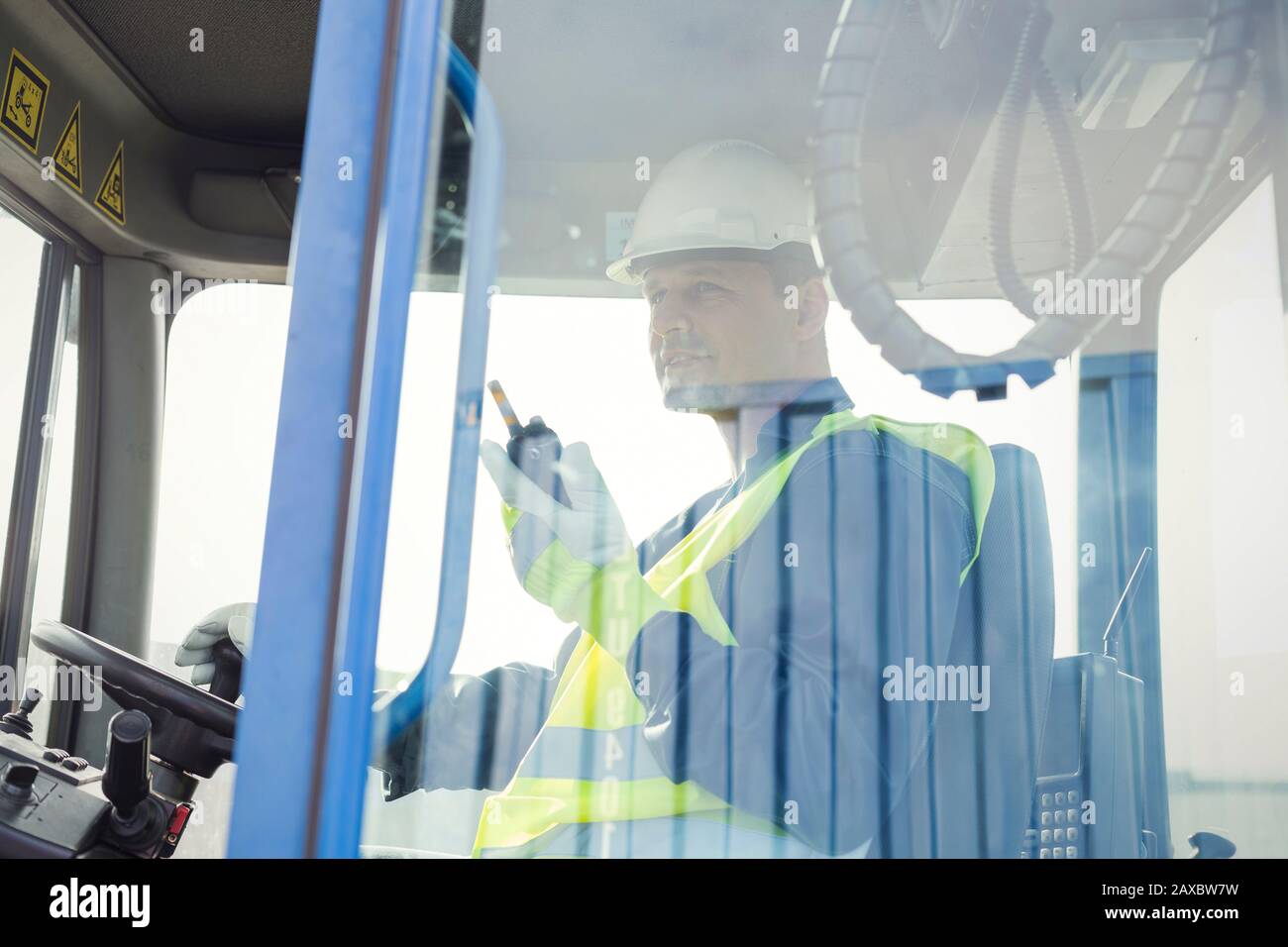 Dock worker with walkietalkie operating forklift Stock Photo Alamy