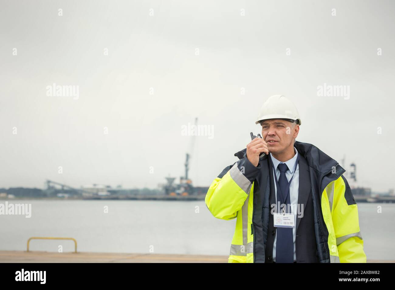 Dock manager using walkie-talkie at commercial dock Stock Photo