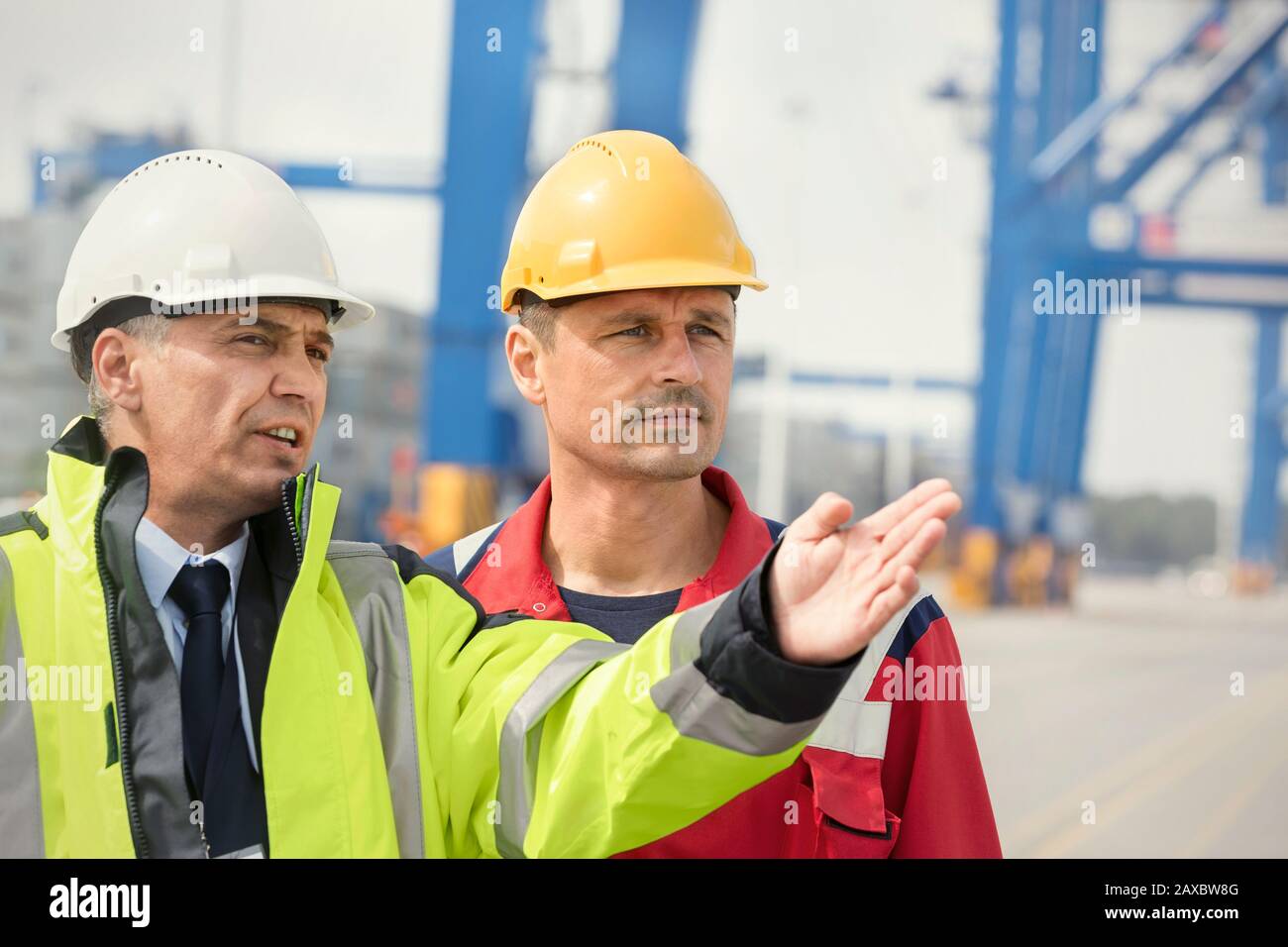 Dock worker and manager talking at shipyard Stock Photo
