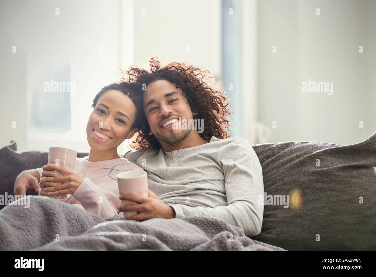 Portrait smiling, affectionate couple relaxing on sofa Stock Photo