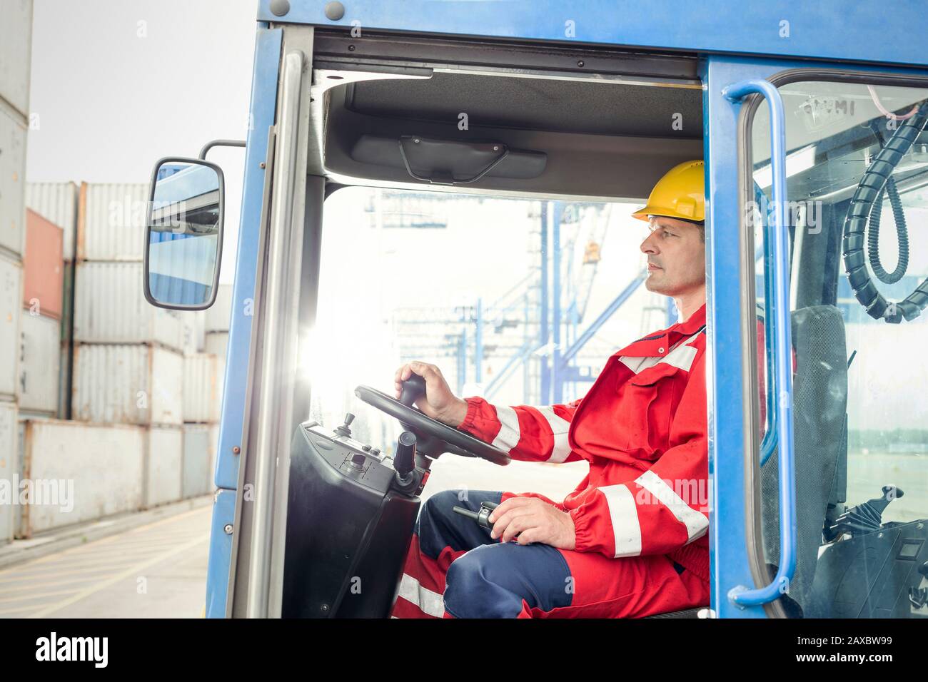 Dock worker operating cargo container forklift at shipyard Stock Photo
