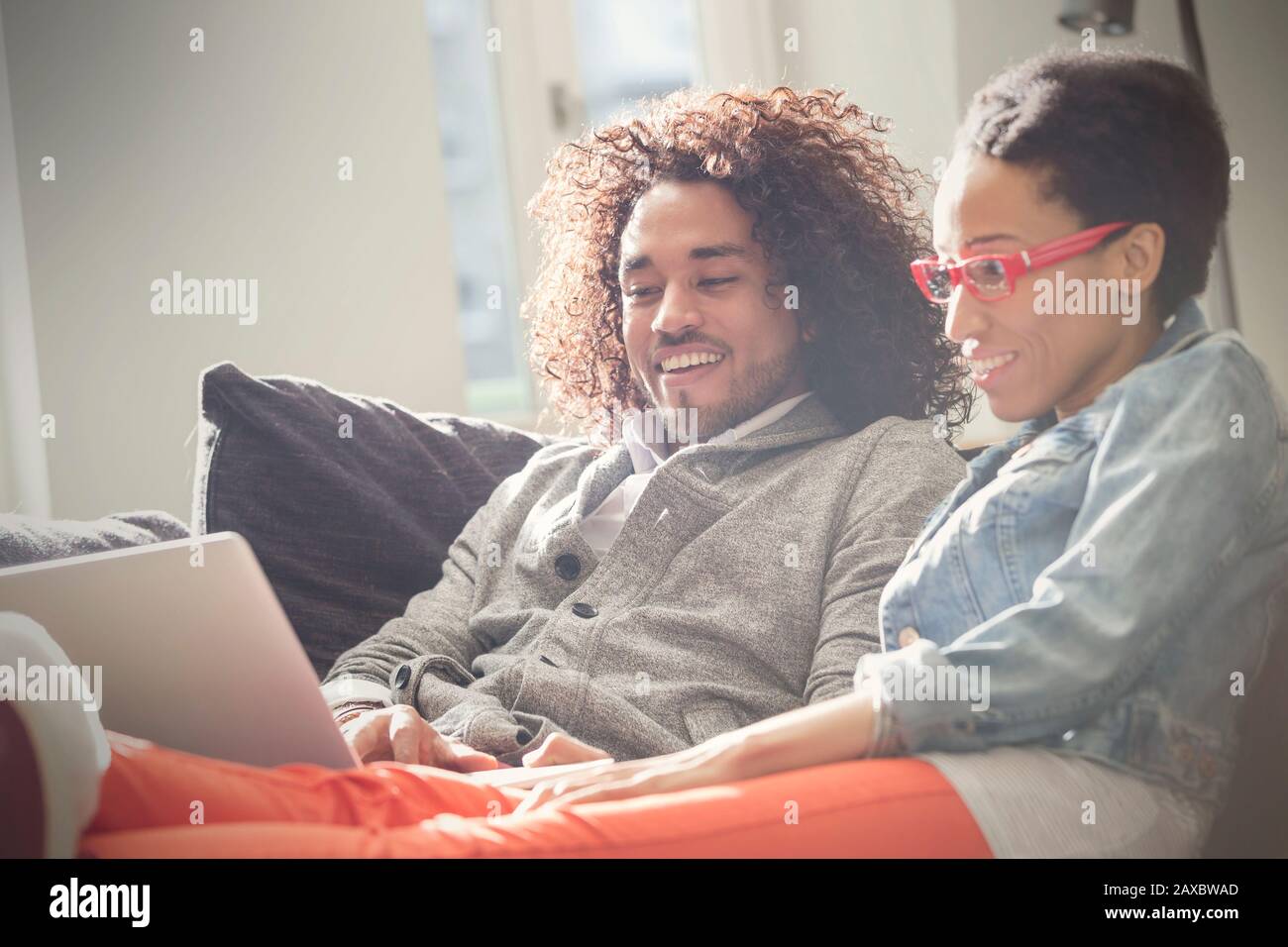 Couple relaxing, using laptop on sofa Stock Photo