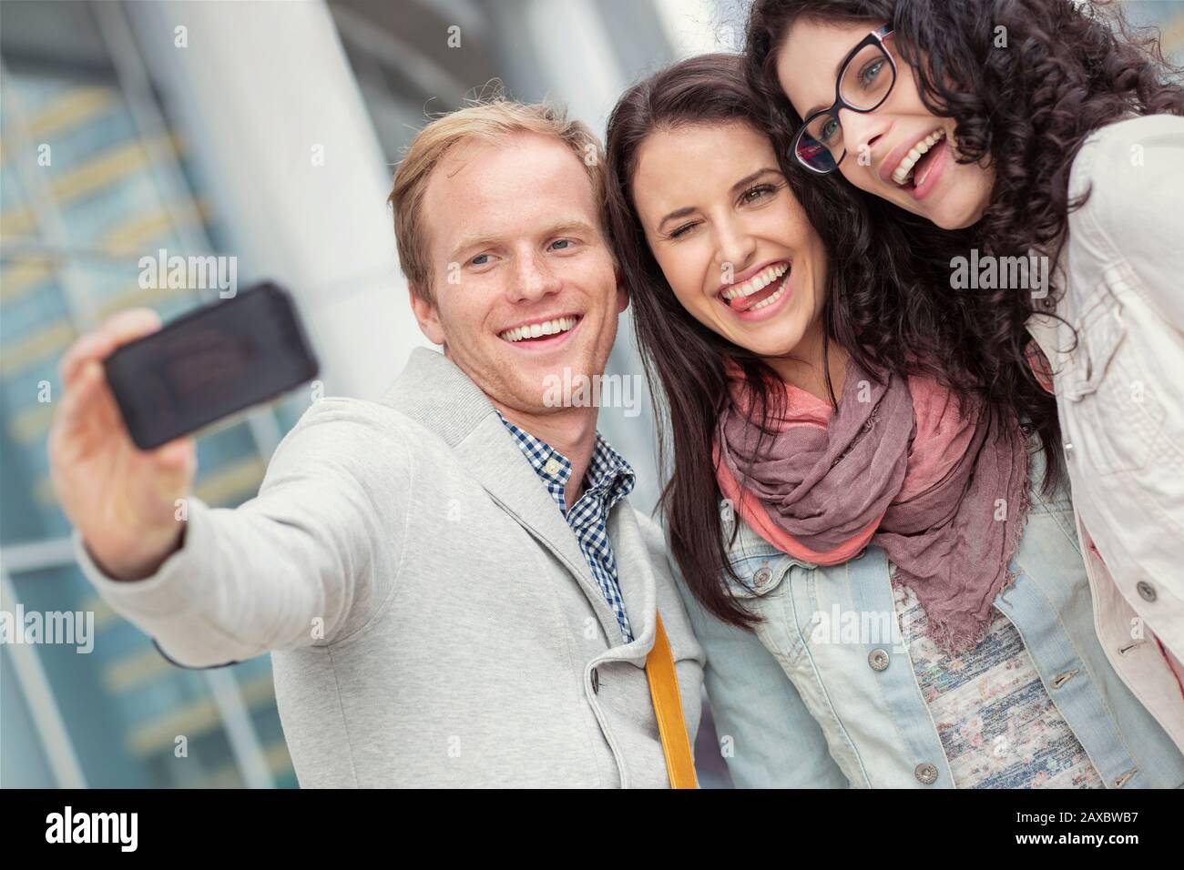 Playful young friends taking selfie with camera phone Stock Photo