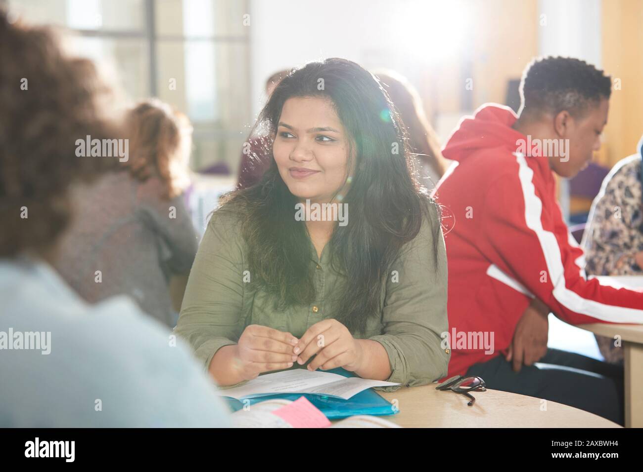 Smiling young female college student studying with classmates Stock Photo