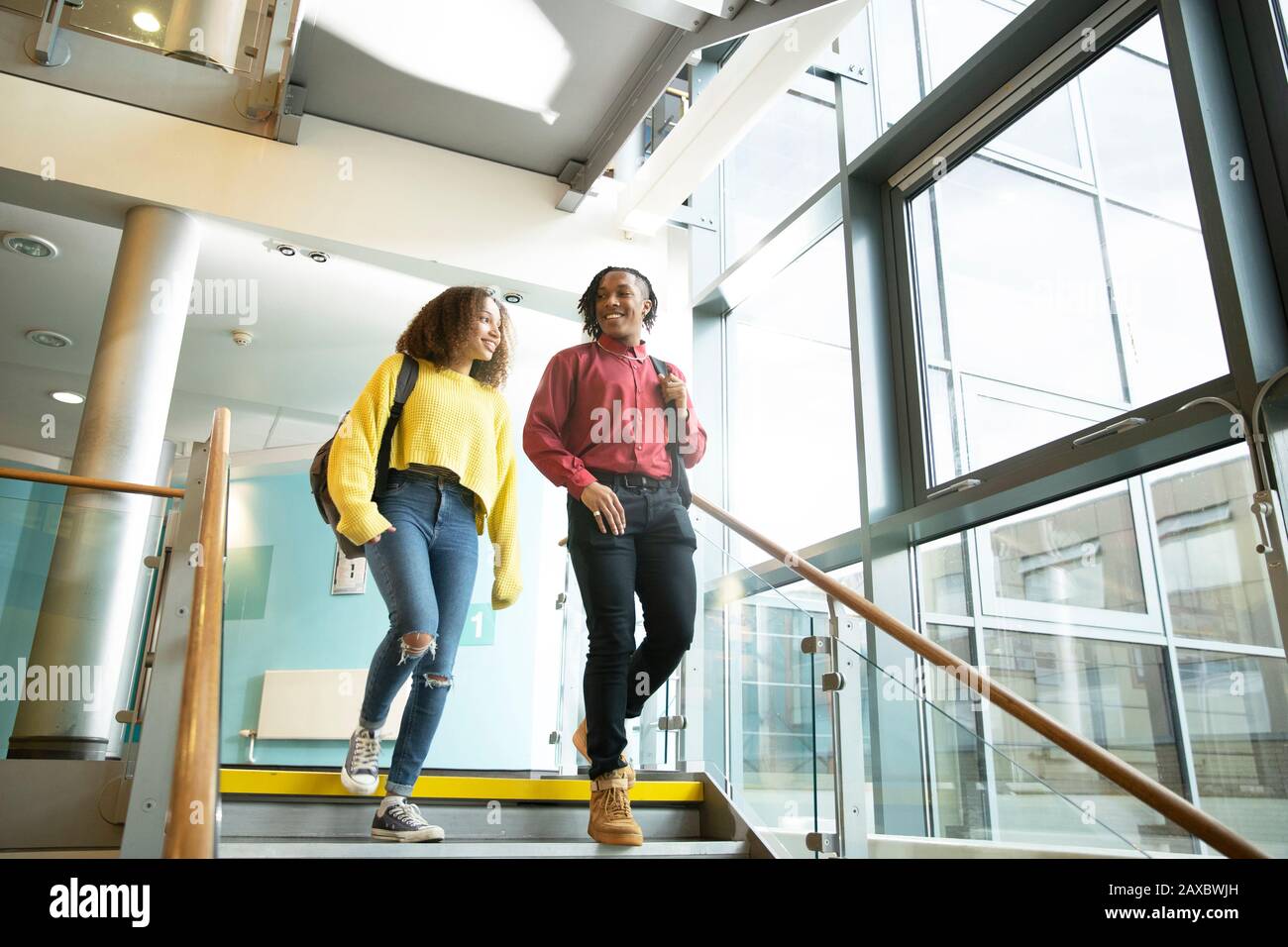 Smiling college students descending staircase Stock Photo