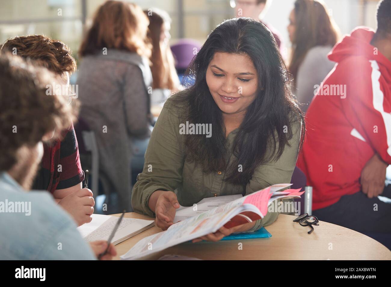 Smiling high school girl student studying with classmates Stock Photo