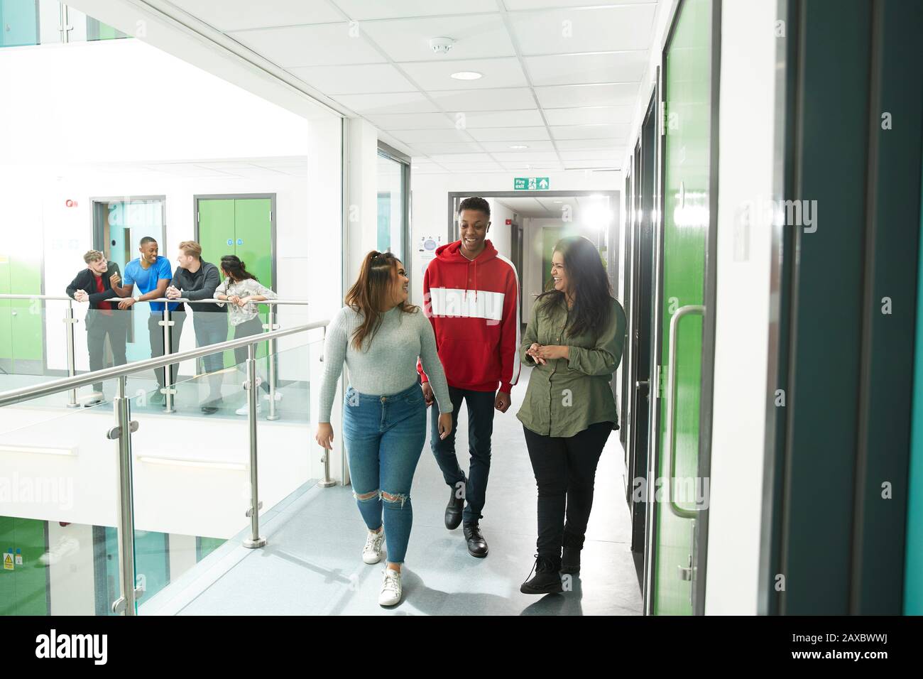 College students walking and talking in corridor Stock Photo - Alamy