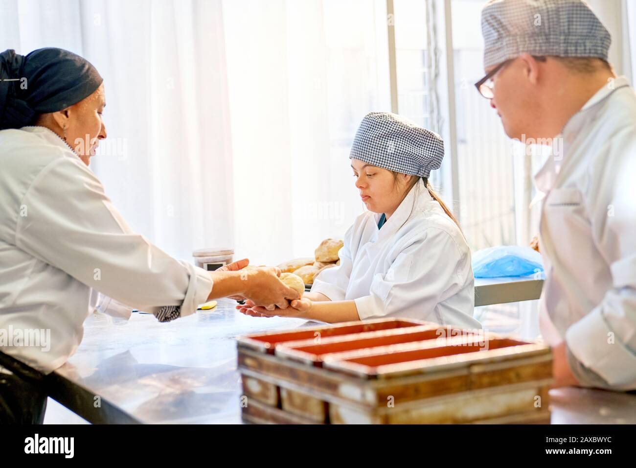 Chef helping students with Down Syndrome in baking class Stock Photo