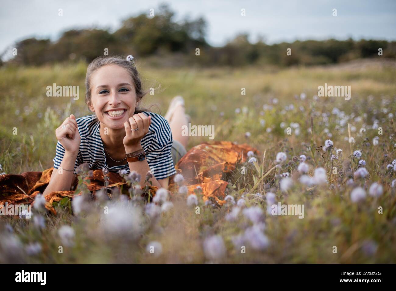 Woman lying down in a field of flowers during daytime Stock Photo - Alamy