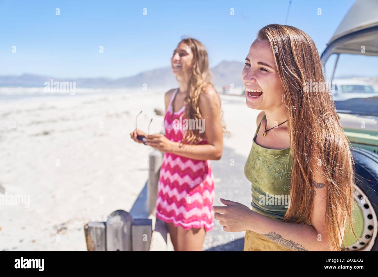 Happy young women friends laughing on sunny beach Stock Photo
