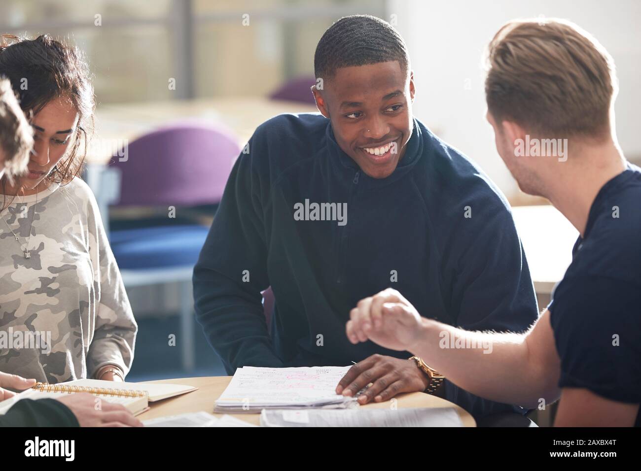 Happy young male college students studying and talking in classroom Stock Photo