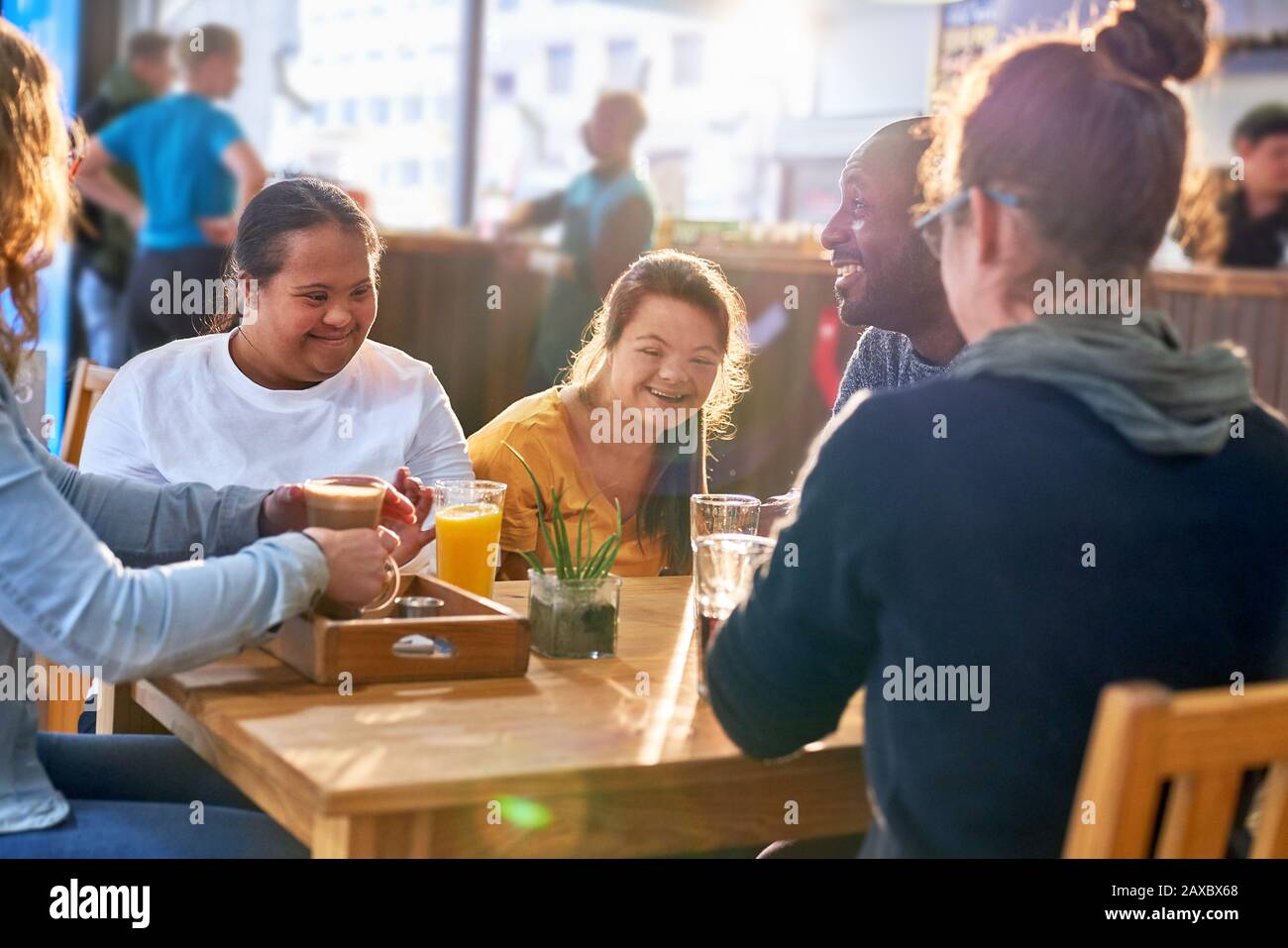 Happy young women with Down Syndrome laughing in cafe Stock Photo