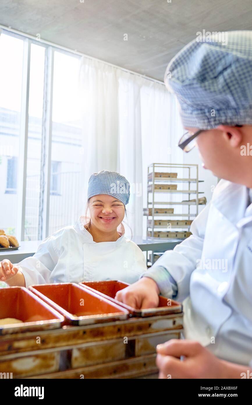 Happy young woman with Down Syndrome baking in kitchen Stock Photo
