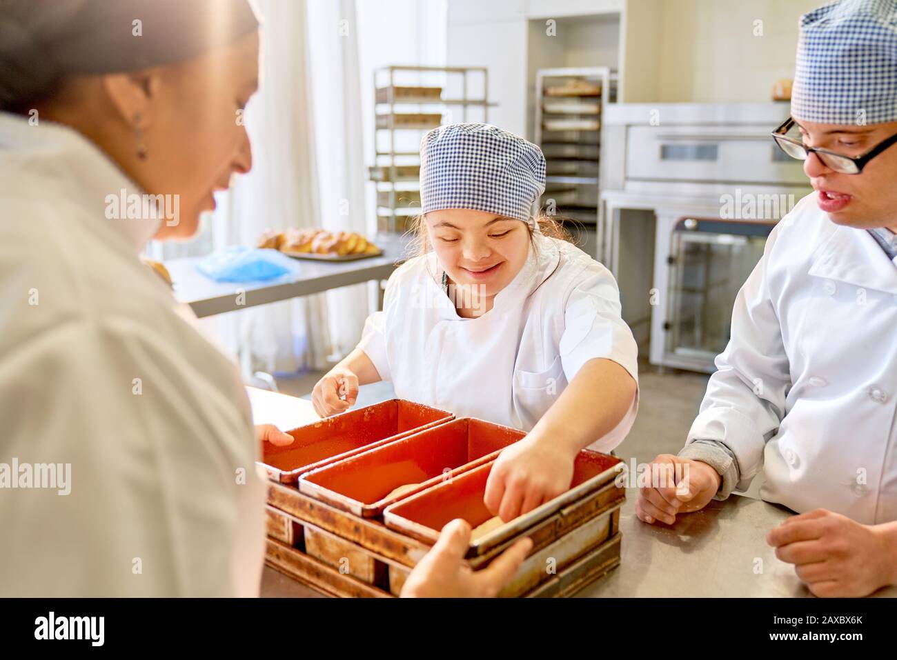 Chef and students with Down Syndrome baking bread in kitchen Stock Photo